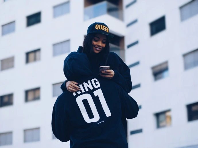 man carrying woman while holding phone