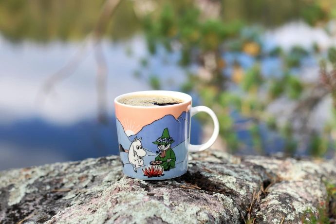 a cup of coffee sitting on top of a rock